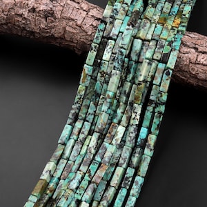 May include: A strand of turquoise gemstone beads, each bead is a rectangular shape with a mottled green and brown pattern.