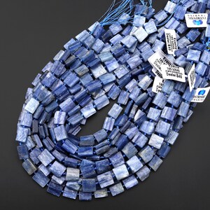 Puede incluir: Collar de cuentas de kianita azul. Las cuentas son rectangulares y est&aacute;n ensartadas en un cord&oacute;n azul. La kianita tiene diferentes tonos de azul. Se ven etiquetas con texto.