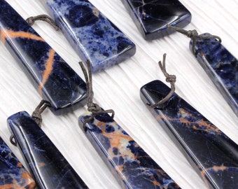 May include: A collection of blue and orange gemstone pendants with brown cords. The pendants are all in the shape of a long, thin triangle.