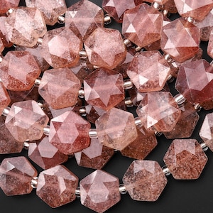Puede incluir: Primer plano de una colección de cuentas facetadas en forma de estrella, en tonos rosas y marrones. Las cuentas están ensartadas con pequeños espaciadores plateados, creando un collar o pulsera.