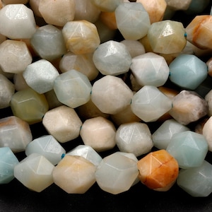 May include: A strand of faceted, light green, brown, and white amazonite beads. The beads are shaped like stars and have a smooth, polished finish.