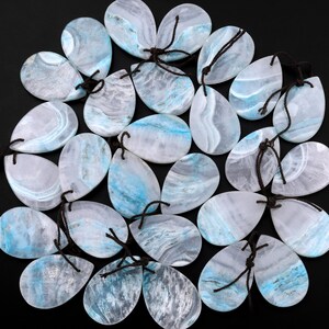May include: A collection of 20 teardrop-shaped pendants made of blue and white agate. Each pendant has a unique pattern of blue and white swirls and is strung with a brown cord.
