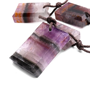 May include: Three purple, black, and brown striped rectangular pendants with a brown cord attached to each.