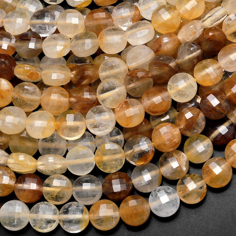 May include: A strand of round, faceted, translucent beads in shades of clear, golden yellow, and brown. The beads are made of natural citrine quartz.