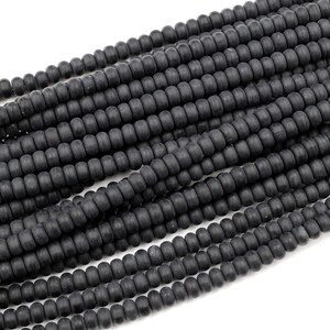 May include: A strand of black matte round beads. The beads are uniform in size and have a smooth, slightly textured surface.