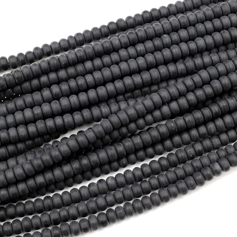 May include: A strand of black matte round beads. The beads are uniform in size and have a smooth, slightly textured surface.