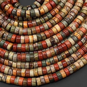May include: A close-up of a strand of colorful, round, gemstone beads. The beads are a mix of brown, red, green, and cream colors. The beads are all about the same size and are arranged in a random pattern.