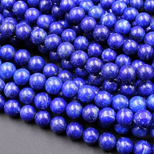 Puede incluir: Una hebra de cuentas redondas de lapisl&aacute;zuli azul. Las cuentas tienen un aspecto moteado y veteado con motas doradas.