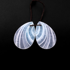 May include: A pair of light blue and white banded teardrop-shaped gemstone pendants with a brown cord.