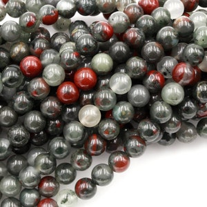 May include: A strand of round, green, red, and clear gemstone beads. The beads are approximately 8mm in diameter and have a smooth, polished finish.