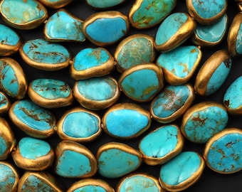 May include: Turquoise gemstone beads with gold accents. The beads are oval shaped and have a smooth, polished finish.
