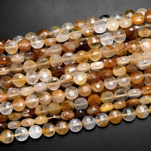 May include: A strand of round, faceted, translucent beads in shades of light brown, yellow, and clear. The beads are made of natural quartz crystal.