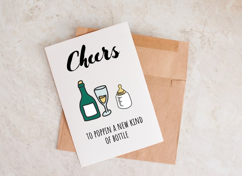 Pode incluir: Um cart&atilde;o branco com o texto "Cheers" em fonte cursiva preta. O cart&atilde;o tem uma garrafa verde, um copo de vinho e uma mamadeira desenhados. O texto "To poppin' a new kind of bottle" est&aacute; impresso abaixo dos desenhos.