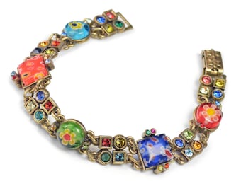 May include: A multi-colored bracelet with a gold chain and colorful glass beads. The beads are decorated with flowers and other patterns.