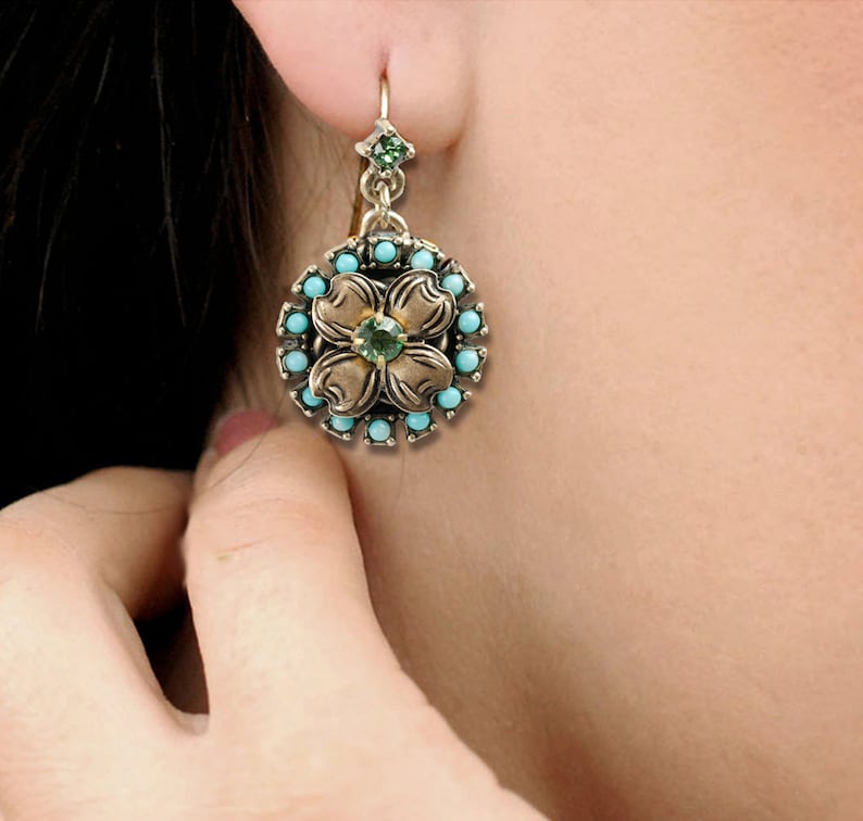May include: A pair of gold-tone earrings with a turquoise and green gemstone flower design.