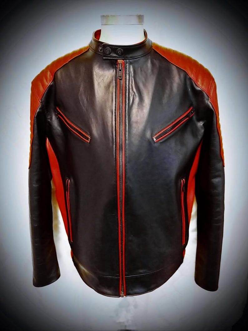 May include: Black and red leather jacket with a stand-up collar and a front zipper. The jacket features red accents on the shoulders, pockets, and zipper trim. A stylish, modern design.
