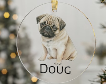 May include: A round, clear glass ornament with a watercolor illustration of a pug dog. The dog is sitting and looking at the camera. The ornament has a gold ribbon and the name "Doug" printed on the bottom.