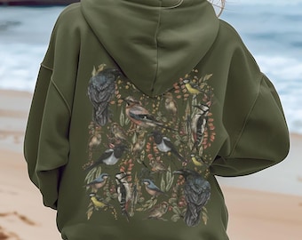 May include: An olive green hoodie with a detailed illustration of various birds and foliage on the back. The design features a variety of bird species in shades of gray, white, yellow, and black, set against a backdrop of brown and green leaves and berries.