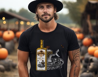 May include: A man wearing a black t-shirt with a graphic of a bottle and a snake. The bottle is labeled "Cure-All" and has a gold and white design. The man is standing in front of a pile of pumpkins.