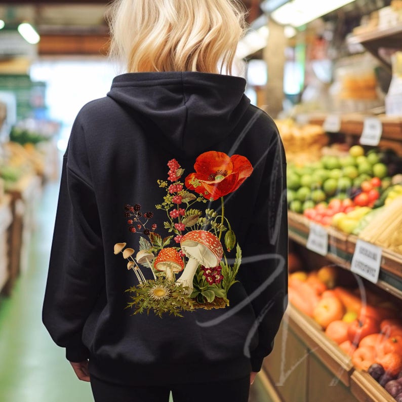 May include: Black hoodie with a floral design featuring red poppies, green leaves, and mushrooms. The design is centered on the back of the hoodie.