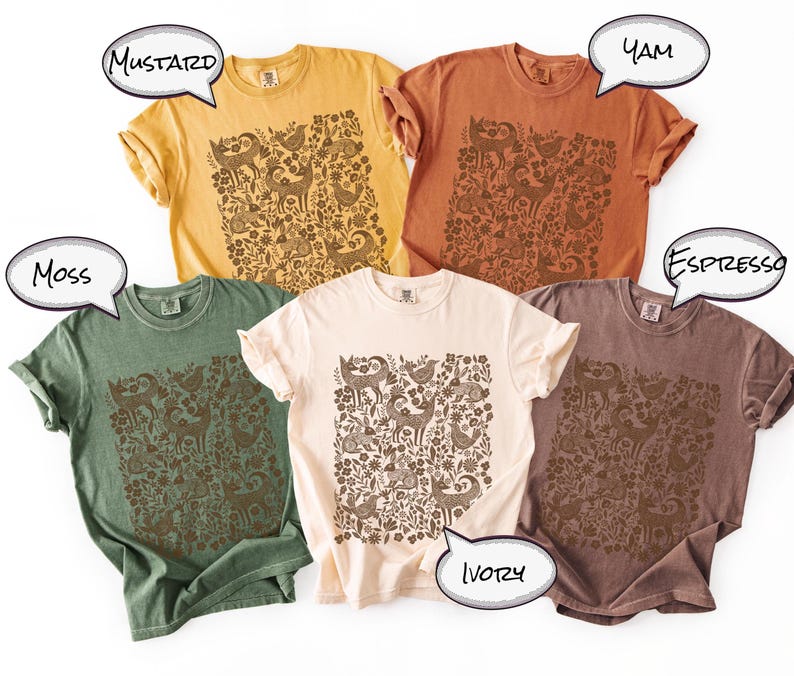 May include: Five different colored t-shirts: mustard, yam, moss, ivory, and espresso. Each shirt features a brown graphic of animals and floral elements. The shirts are short-sleeved and have a relaxed fit.