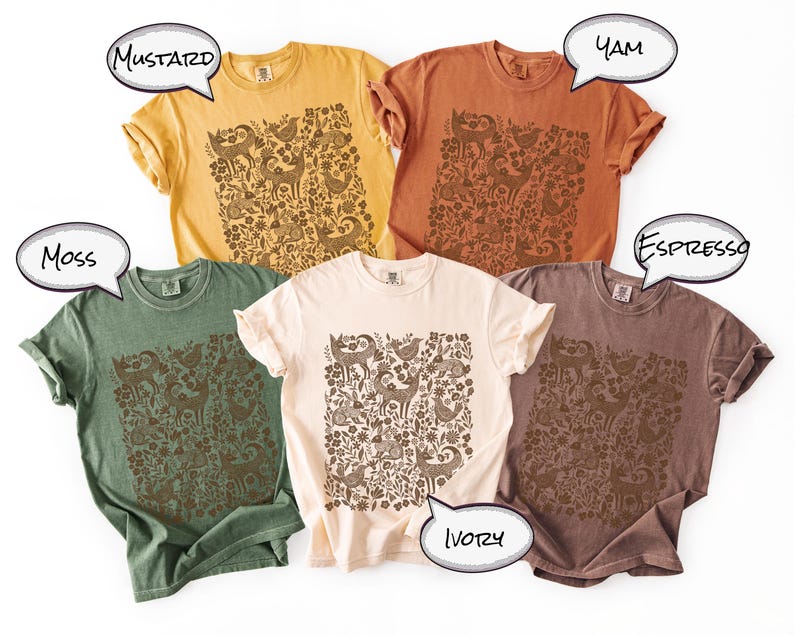May include: Five different colored t-shirts: mustard, yam, espresso, ivory, and moss. Each shirt features a brown floral and animal pattern. The shirts are short-sleeved and have a relaxed fit.