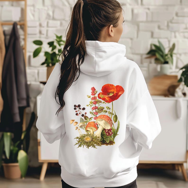 May include: White hoodie with a floral print featuring red poppies, mushrooms, and green leaves.