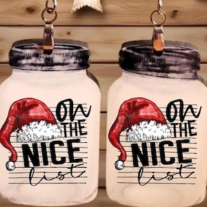 Op de afbeelding: Een paar kerstoorbellen in de vorm van weckpotten. Elke pot heeft een rood kerstmutsontwerp met de tekst "On the Nice List" in het zwart. De oorbellen hangen aan zilverkleurige haken.