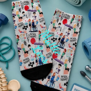 May include: A pair of white socks with black heels, featuring a repeating pattern of physical therapy-related illustrations and the text "PHYSICAL THERAPIST". The design includes images of people, exercise equipment, and medical symbols.