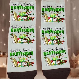 May include: A pair of white socks with black heels and toes. The socks feature a festive design with a cocktail shaker, a cocktail, and the text "Santa's favorite BARTENDER" in green.