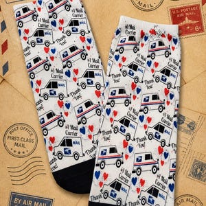 May include: Pair of white socks with a repeating pattern of mail trucks, hearts, and the text "#1 Mail Carrier" and "Thank You!". The socks have black toes and heels, and are set against a background of vintage postage stamps.