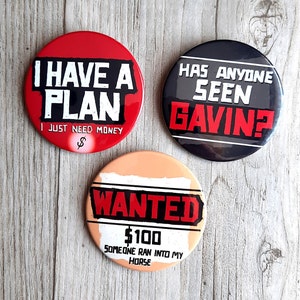 Puede incluir: Tres botones redondos con diferentes diseños. El primer botón es rojo con texto blanco que dice "Tengo un plan Solo necesito dinero". El segundo botón es gris con texto blanco que dice "¿Alguien ha visto a Gavin?" El tercer botón es melocotón con texto blanco que dice "SE BUSCA 100 € Alguien se ha topado con mi caballo".