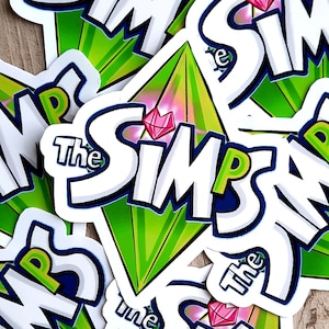 May include: Multiple stickers featuring the The Sims logo. The logo is white with a green diamond shape and a pink gem in the center. The text "The Sims" is in a bold white font.
