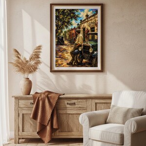 May include: A framed wall art print depicting a textured oil painting of a person leaning against a vintage green car on a sunlit street. The scene features warm yellow and orange tones, deep shadows, and a building with a sign in the background.