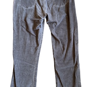 Könnte beinhalten: Graue Cordhose mit geradem Bein und zwei Gesäßtaschen.