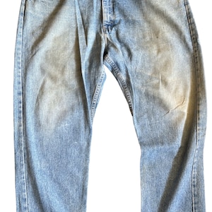 May include: A pair of light blue denim jeans with a classic straight leg fit. The jeans have a faded look and are made of a soft, comfortable cotton blend.