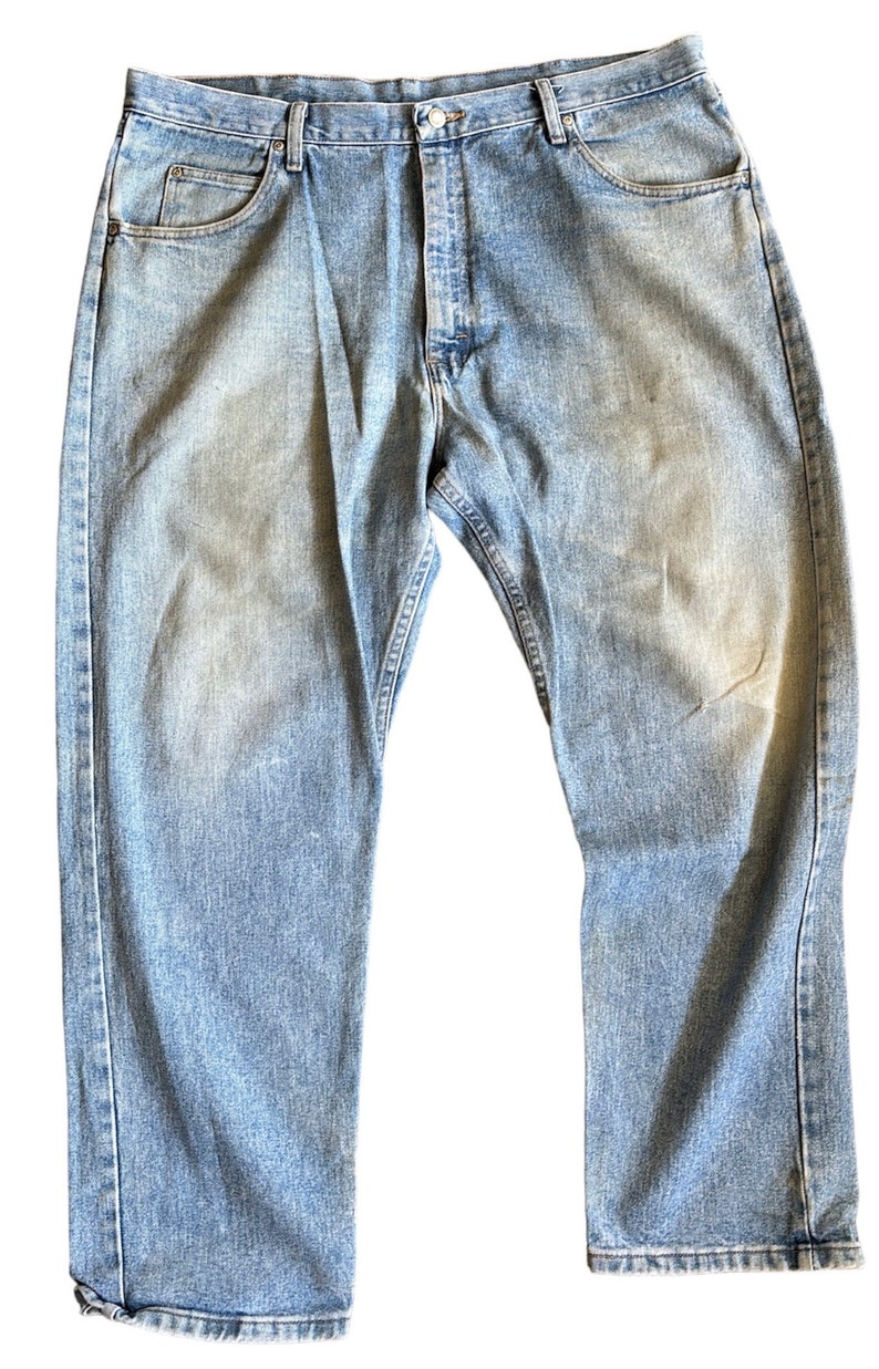 May include: A pair of light blue denim jeans with a classic straight leg fit. The jeans have a faded look and are made of a soft, comfortable cotton blend.