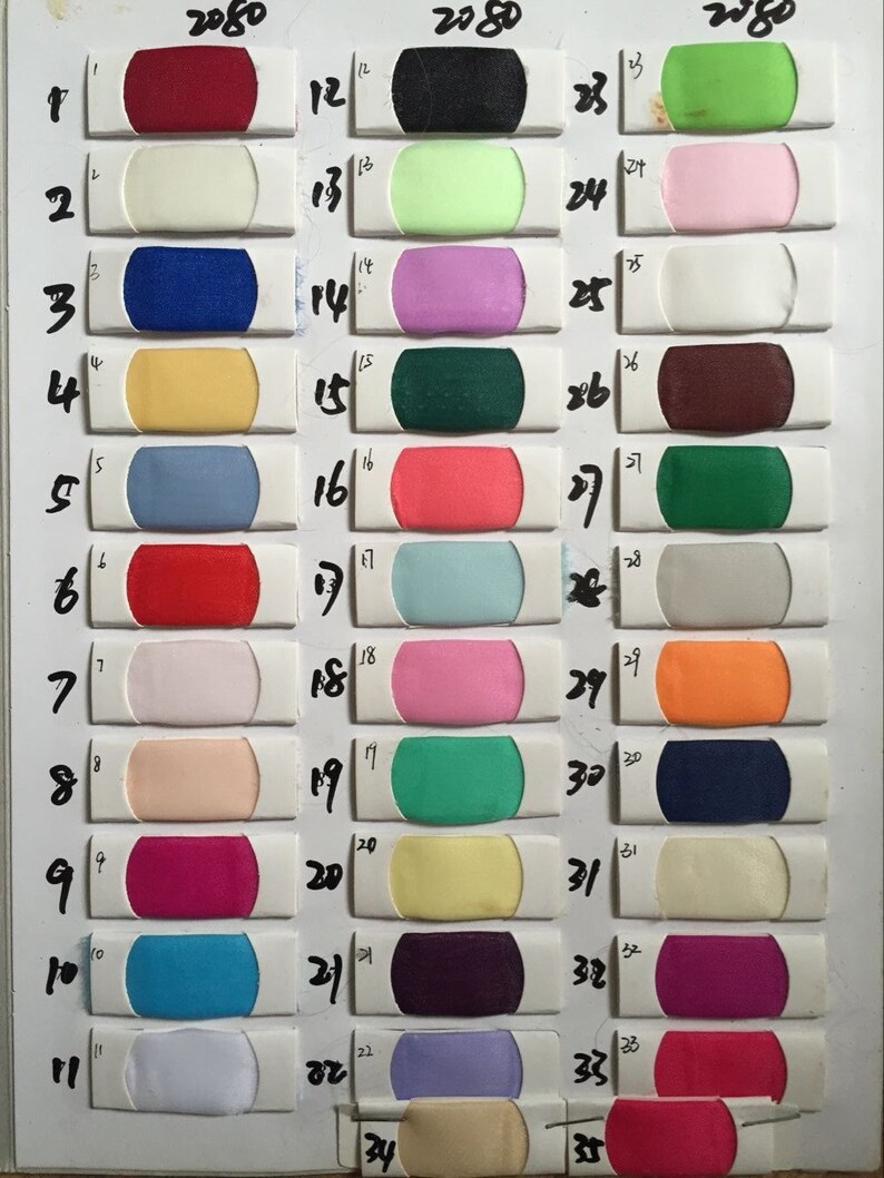 Puede incluir: Carta de colores con 35 muestras de tela en varios colores, incluyendo rojo, azul, verde, amarillo, rosa, naranja, blanco, negro y morado. La carta est&aacute; etiquetada con los n&uacute;meros del 1 al 35.