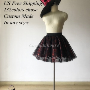 Pu&ograve; includere: Una gonna di tulle nera con accenti di glitter rosso. La gonna &egrave; su un manichino che indossa un cappello da strega nero con un nastro rosso. Il testo "US Free Shipping 132colors chose Custom Made In any sizes" &egrave; visibile nell'immagine.