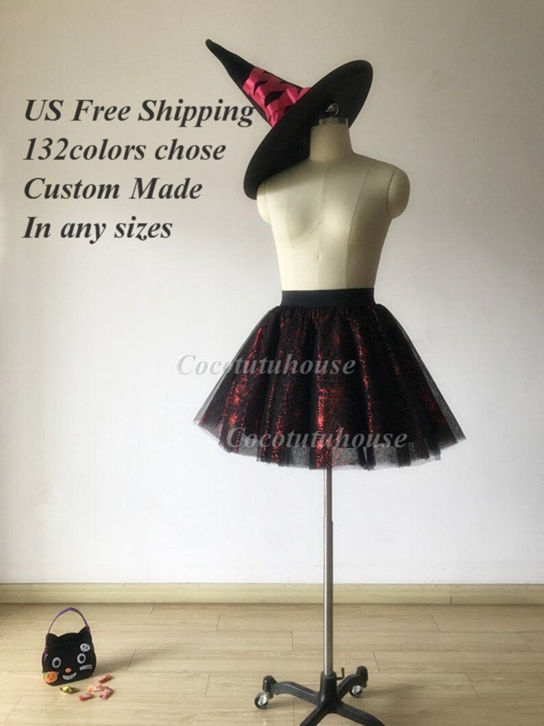 Pu&ograve; includere: Una gonna di tulle nera con accenti di glitter rosso. La gonna &egrave; su un manichino che indossa un cappello da strega nero con un nastro rosso. Il testo "US Free Shipping 132colors chose Custom Made In any sizes" &egrave; visibile nell'immagine.