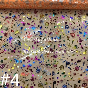 Pu&ograve; includere: Un foglio di tessuto trasparente e chiaro con un motivo ripetuto di immagini colorate a tema Halloween, tra cui zucche, pipistrelli, stelle e ragnatele. Il tessuto &egrave; decorato con glitter iridescente. Il testo "#4" &egrave; visibile nell'angolo inferiore sinistro dell'immagine.