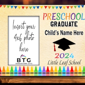 May include: A wooden preschool graduation photo frame with a 4x6 photo opening. The frame features colorful text that reads "Preschool Graduate" and "Child's Name Here" with a graduation cap graphic and the year 2024.