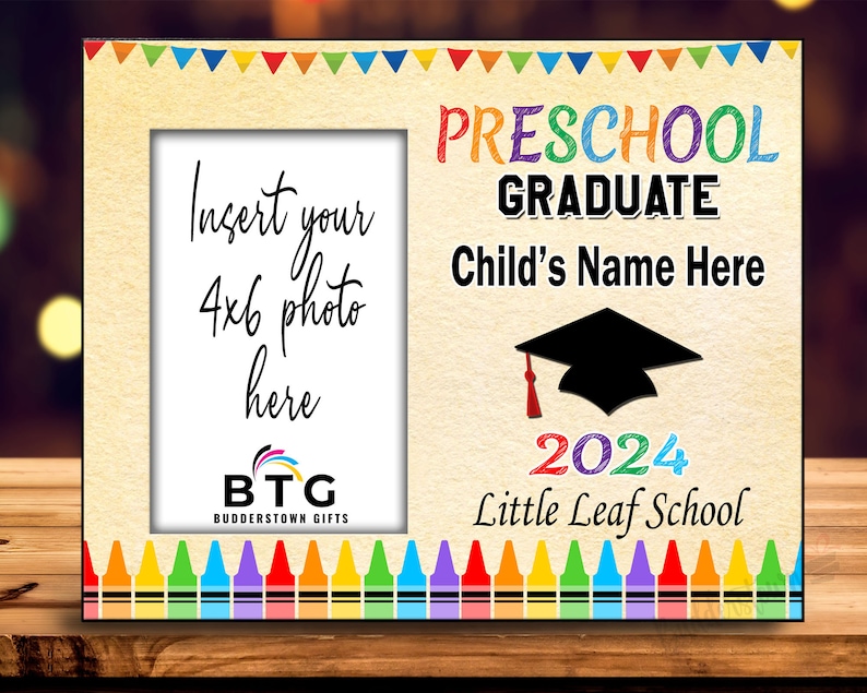 May include: A wooden preschool graduation photo frame with a 4x6 photo opening. The frame features colorful text that reads "Preschool Graduate" and "Child's Name Here" with a graduation cap graphic and the year 2024.