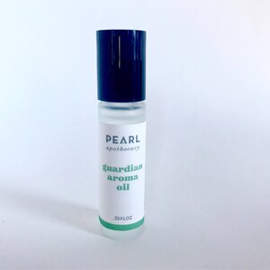 May include: A clear glass bottle with a black roll-on top. The bottle is labeled "PEARL apothecary guardian aroma oil .35FL OZ".