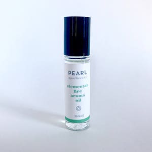May include: A clear glass roller bottle with a black cap and a white label that reads "PEARL apothecary elemental fire aroma oil .33 FLOZ".