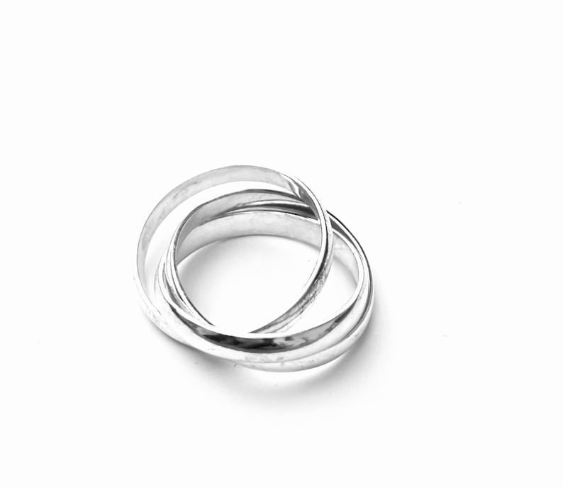 May include: A silver interlocking ring set. The rings are smooth and polished.