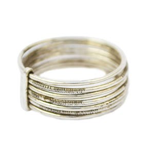 May include: A silver ring with multiple bands, featuring a textured design on some of the bands. The ring has a simple, elegant design, suitable for everyday wear. The ring is made of a shiny, metallic material.
