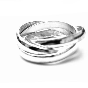 May include: A silver interlocking ring set with a polished finish.