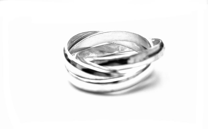 May include: A silver interlocking ring set with a polished finish.