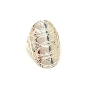May include: A silver ring with an oval-shaped design featuring intricate geometric patterns.